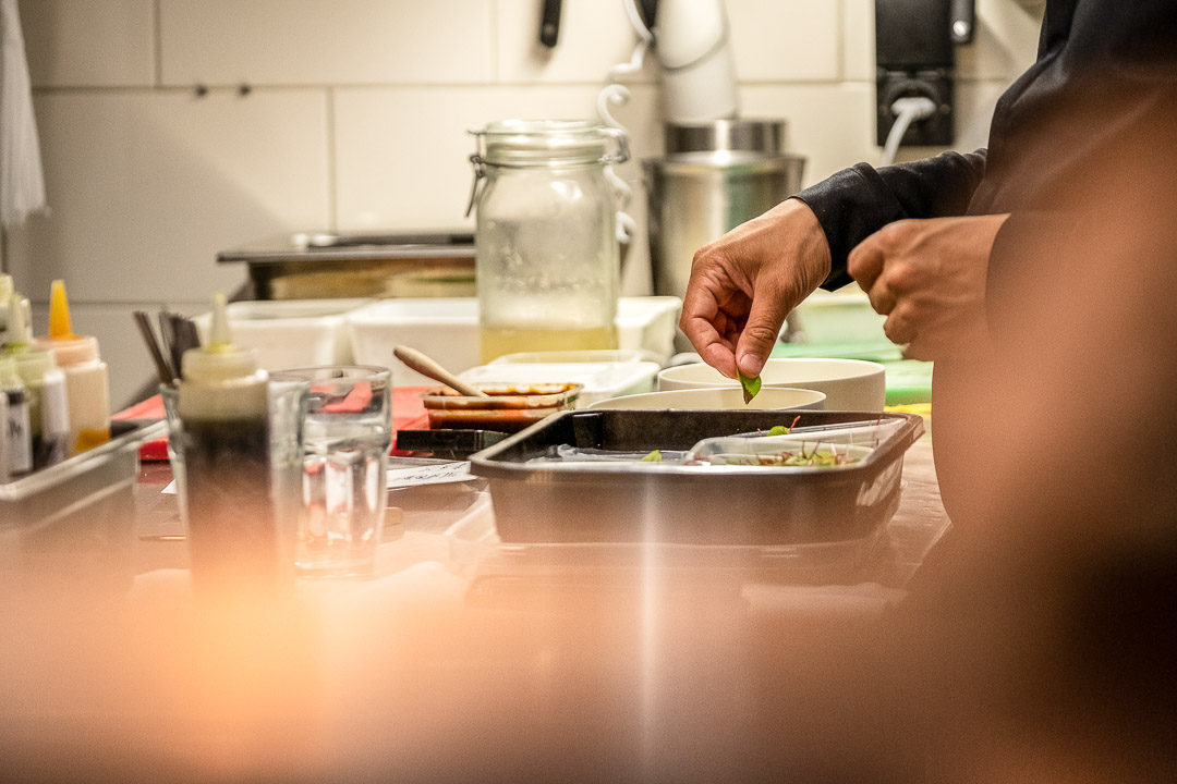 Dennis Huwaë garnishing a dish in the kitchen at Restaurant Daalder in Amsterdam.