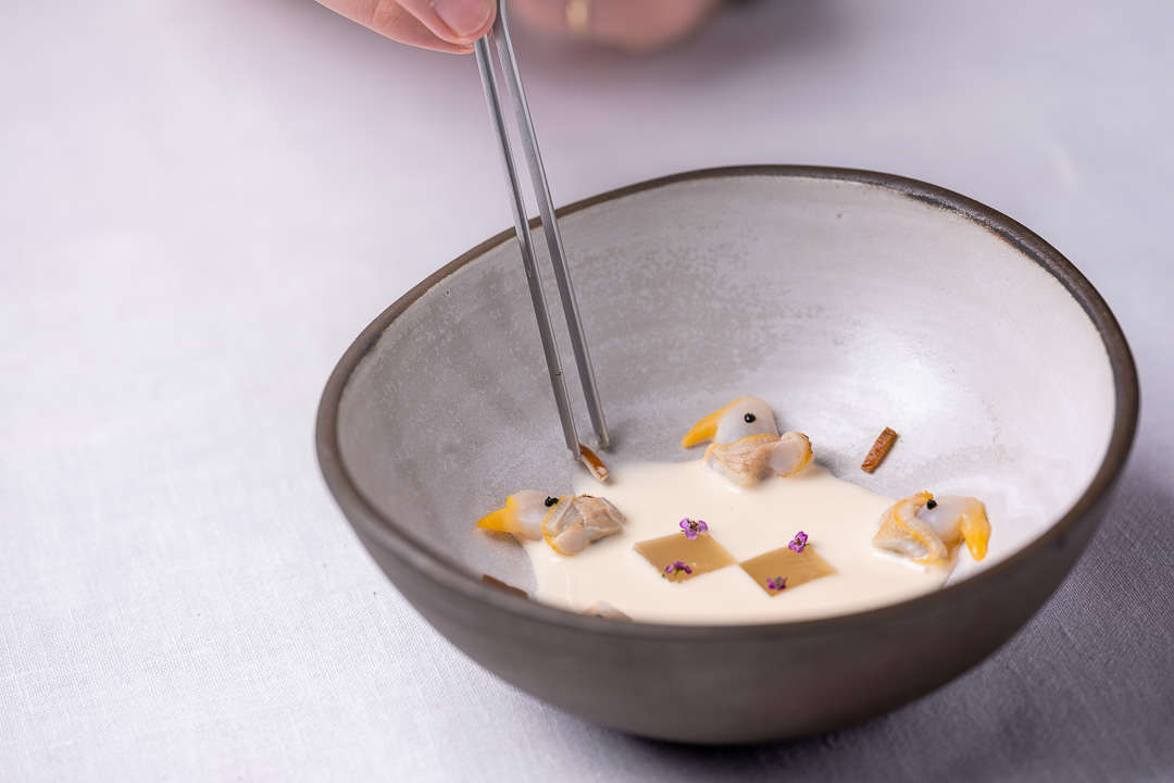 Aponiente by Hungry for More. Gazpachuelo berberecho, cockles and Andalusian cold soup. Front action view 02.