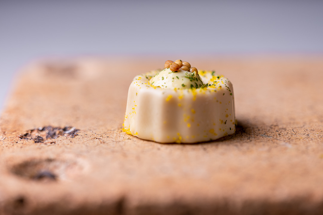 Aponiente by Hungry for More. Sardine canelé, classic petit fours from Bordeaux, made of dried sardines and mustard. Close-up.